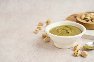 Fıstık ezmeli kase ve pembe grunge arka planda kaşık