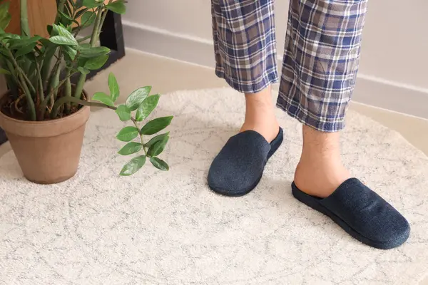 Evde mavi terlik giyen adamın bacakları. Yakın çekim.