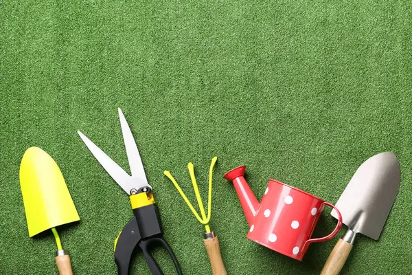 Yeşil çimen arka planında bahçe işleri için araçlar. Üst görünüm