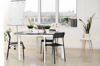 Çalışma alanı, penceresi ve bitkileri olan modern ofisin içi