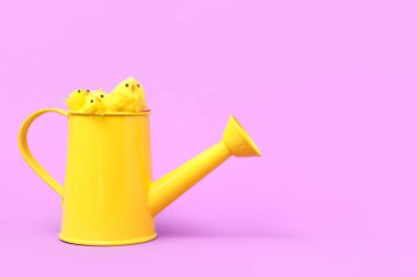 Sarı sulama kutusu, arka planda oyuncak tavuklar.