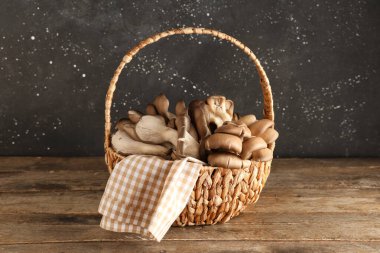 Tahta masada taze istiridye mantarlı sepet.