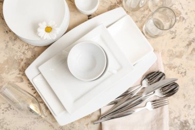 Temiz tabaklar, papatya çayı, hafif arka planda bardaklar ve çatal bıçak takımı.