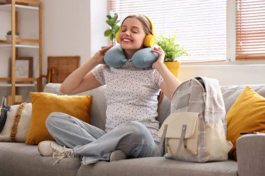 Kulaklıklı genç hamile kadın evde tatile hazır.