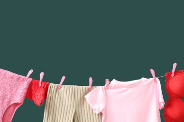 Yeşil arka planda temiz kıyafetler ve iç çamaşırları, yakın plan.