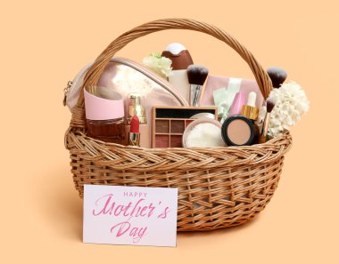 Dekoratif kozmetik ürünleri, çiçekler ve kartla birlikte Anneler Günü kutlaması için renkli arka planda hediye sepeti.
