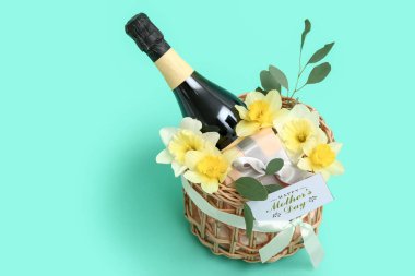 Anneler Günü kutlamaları için bir şişe şampanya ve güzel narsisli çiçekler.