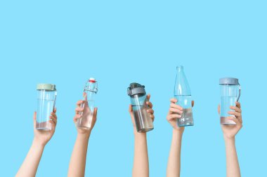 Renkli arka planda farklı su şişeleri olan kadın eller, yakın plan