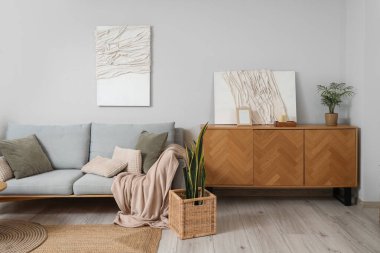 Konforlu kanepesi, çiçekleri ve resimleri olan bir ışık odası.