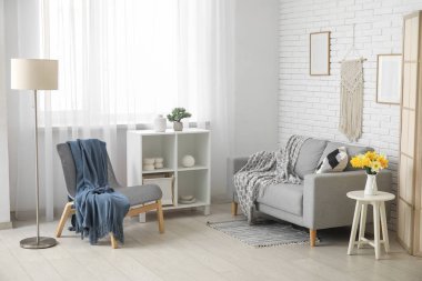 Oturma odasının içinde ekoseli rahat bir kanepe ve koltuk.