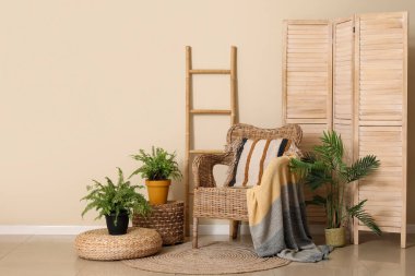 Oturma odasının içinde yastıklı ve ekoseli saman koltuklar.