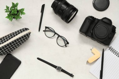 Işık arka planında fotoğrafçı ekipmanı, cep telefonu ve gözlüklü kompozisyon