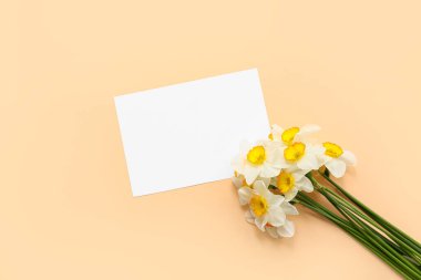 Turuncu arka planda bir buket güzel nergis çiçekli boş kart.