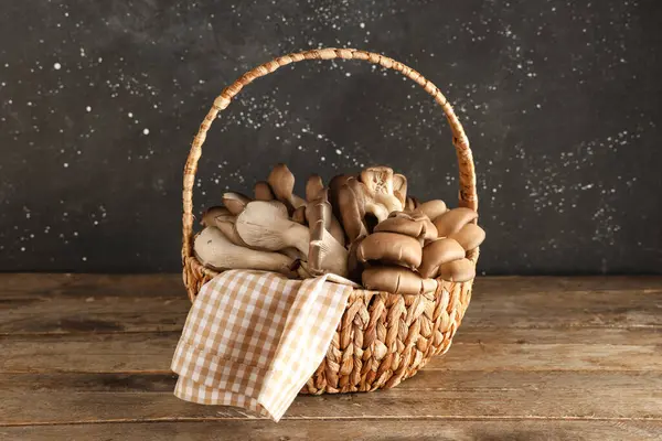 Tahta masada taze istiridye mantarlı sepet.