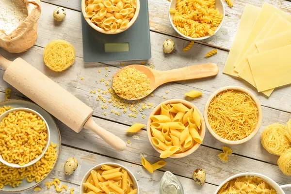 Farklı tipte çiğ makarna ve mutfak gereçleri.