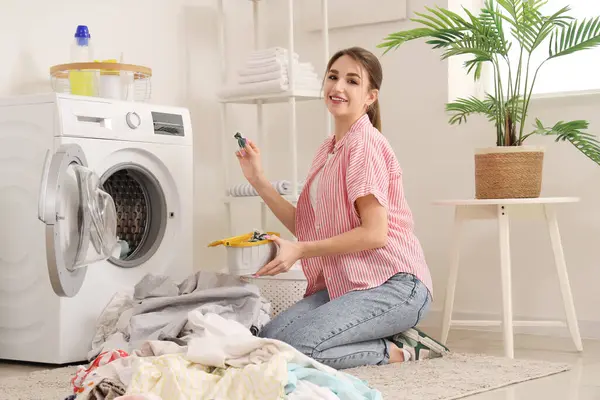 Kirli çamaşırları ve çamaşır deterjanı olan genç bir kadın.
