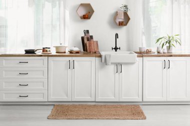 Beyaz tezgahlı, aydınlık, modern mutfağın içi.