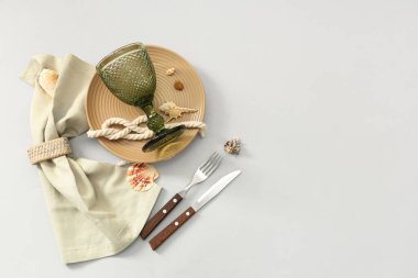 Gri arka planda deniz kabukları ve halatla güzel bir masa.