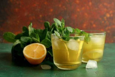 Lezzetli limonata dilimlenmiş limon ve yeşil grunge masasında nane şekeri.
