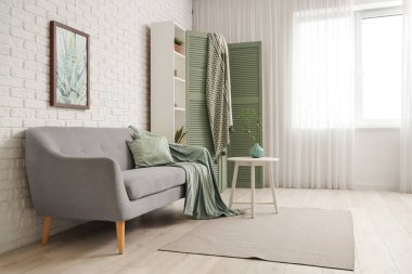 Güzel, şık bir oda, rahat bir kanepe, raflar ve katlanır ekran.