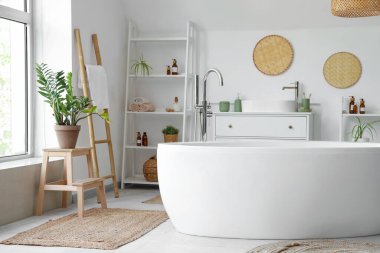 Beyaz küvetli ve çiçekli bir banyo.