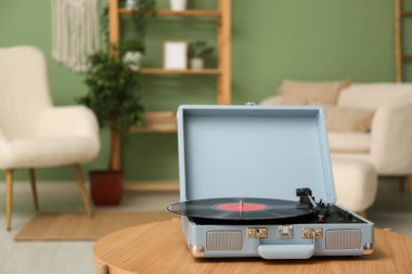 Odadaki sehpanın üzerinde diski olan bir plak çalar.