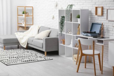 Oturma odasının içinde raflar, kanepe ve pikap sehpanın üzerinde.