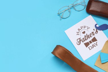 Mavi arka planda mutlu babalar günü yazılı aksesuar ve kağıt. Üst görünüm