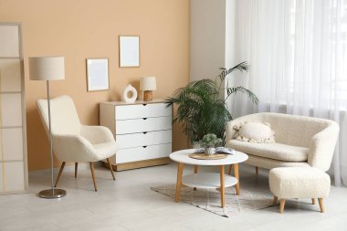 Oturma odasında rahat bir kanepe, koltuk ve sehpa var.