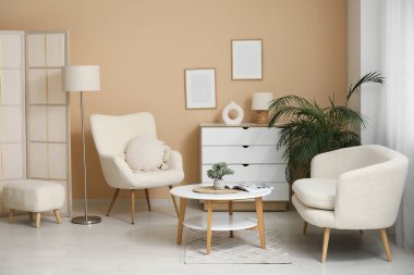 Oturma odasının içinde rahat bir kanepe, koltuk ve kahve masası.