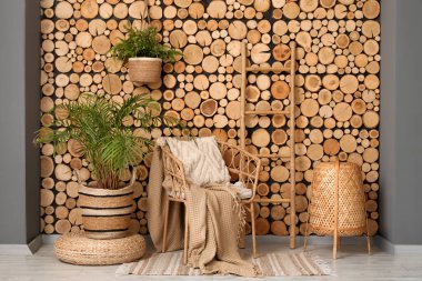 Hasır koltuklu, çiçekli, ekose ve merdivenli güzel bir oturma odası.