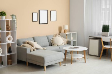 Rahat kanepesi, sehpası, işyeri ve perdesi olan şık bir oturma odası.