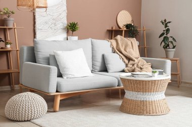 Rahat kanepe, yastık, sehpa ve ekoseli bir oturma odası.