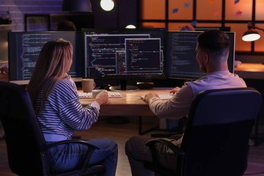 Geceleri ofiste çalışan genç programcılar, arka plan