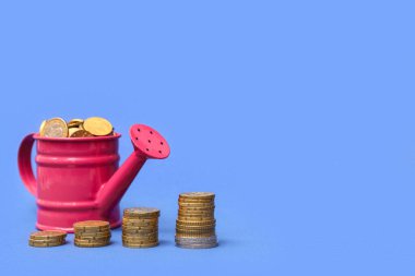 Renk arkaplanında bozuk paralar olan pembe sulama kutusu