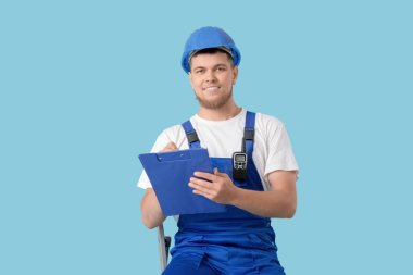 Erkek müteahhit mavi arkaplanda panoya yazı yazıyor