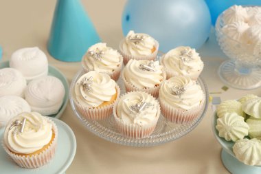 Tatlı standları, lezzetli beyaz kekler, dekor ve doğum günü partisi için diğer tatlılar masada.