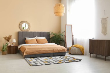 Sıcak yatak, ayna ve lamba güzel yatak odasındaki komodinin üzerinde.