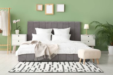 Rahat yatak, yastıklar ve şık yatak odasındaki komodinlerin yanında.