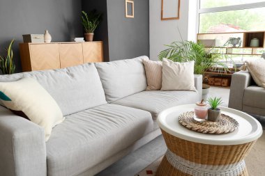 Interior of living room with cozy grey sofa and coffee table