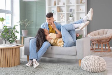 Happy young couple spending time together on sofa at home