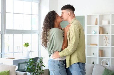 Happy young beautiful couple kissing at home