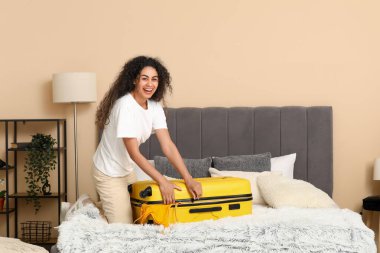 Güzel, genç, mutlu bir kadın. Evdeki yazlık kıyafetleri açıyor.