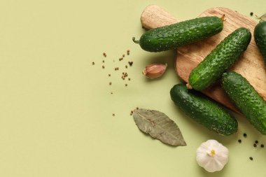 Taze yeşil salatalıklı ahşap tahta ve farklı renklerde baharatlar.