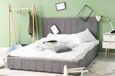 Çerçeveli ve elbise askılı dağınık bir yatak odası.