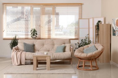 Rahat kanepesi, koltuğu, sehpası ve katlanır ekranı olan şık bir oturma odası.