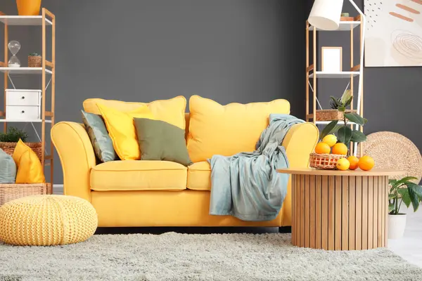 Süslü oturma odasındaki sarı kanepenin yanındaki sehpanın üzerinde turkuazlar var.