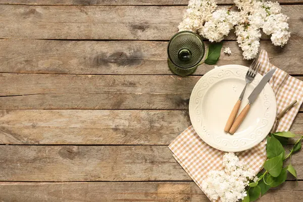 Ahşap arka planda beyaz leylak çiçekleri olan güzel bir masa.