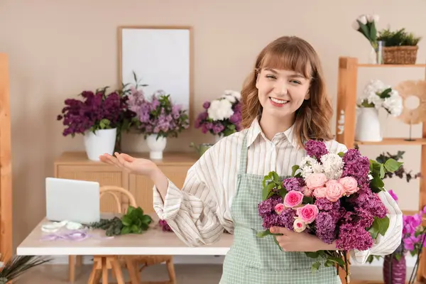 Çiçekçide elinde leylaklarla güzel bir buket tutan kadın çiçekçi.