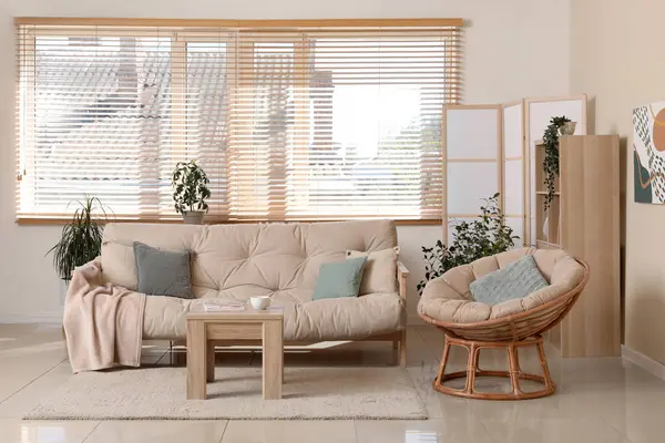 Rahat kanepesi, koltuğu, sehpası ve katlanır ekranı olan şık bir oturma odası.